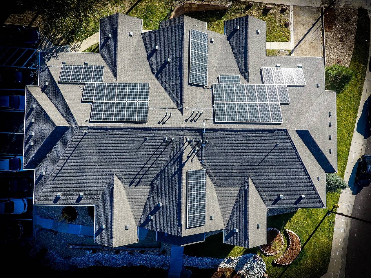 aerial view of a large home with many solar panels installed, eco friendly, green building